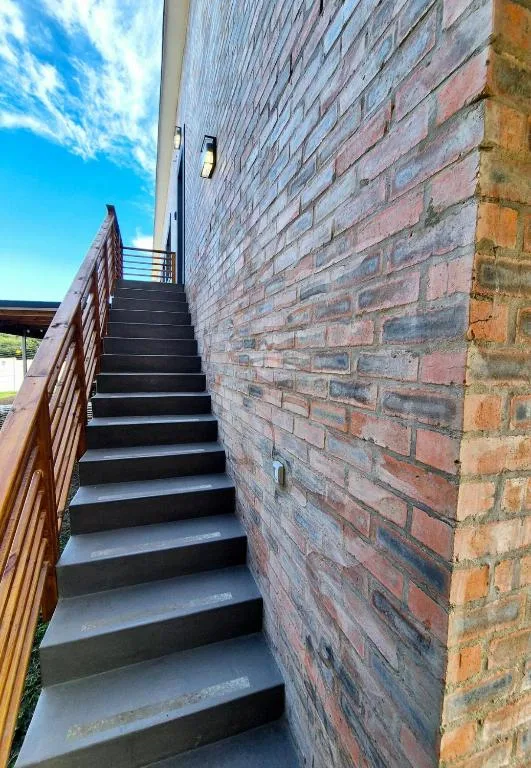External staircase with metal railing against brick building facade