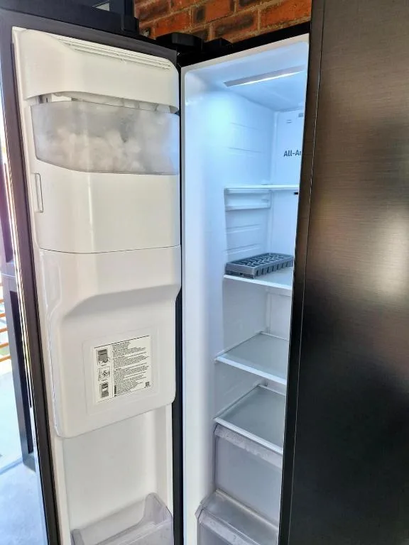Open refrigerator showing empty shelves and freezer compartment