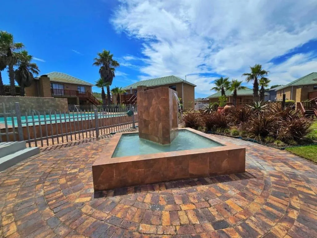Paved courtyard with shallow pool feature and palm trees