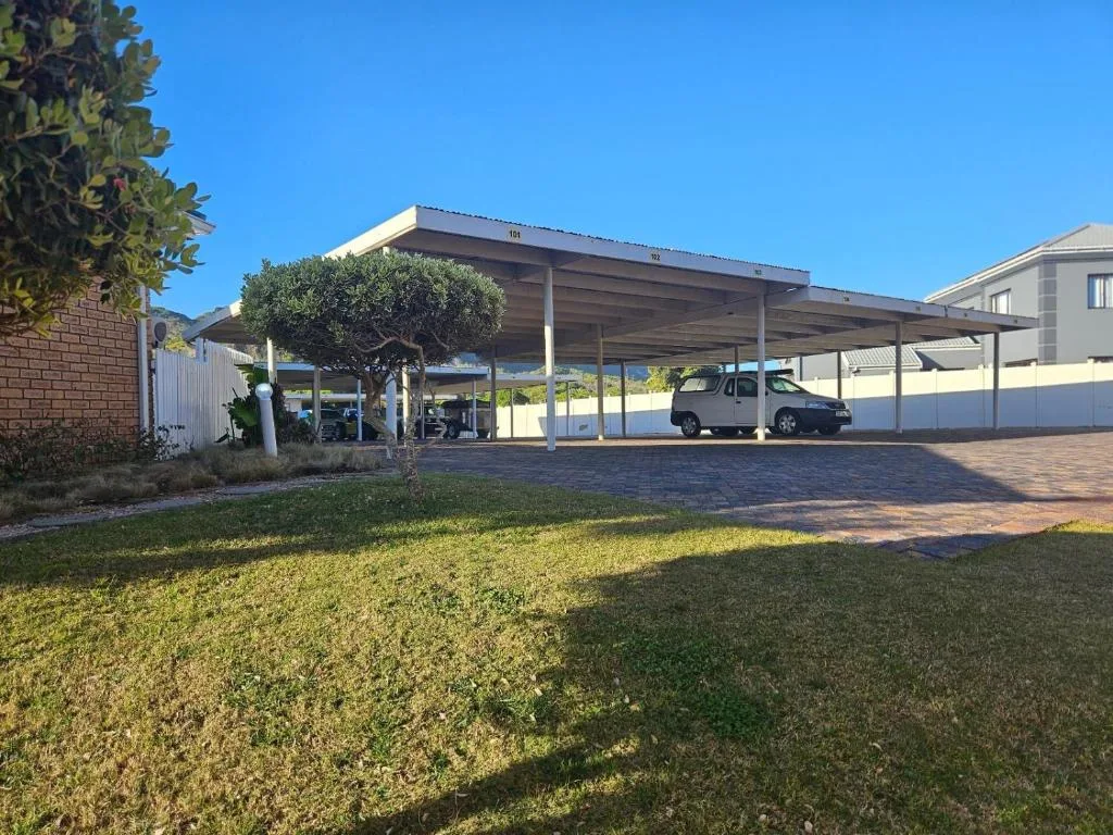 Modern carport with parked vehicle and manicured lawn in front