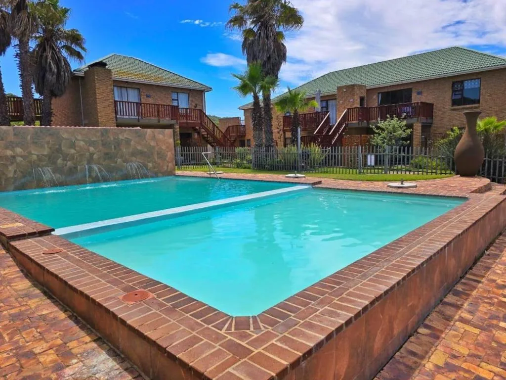 Sparkling turquoise swimming pool with brick surround and residential buildings