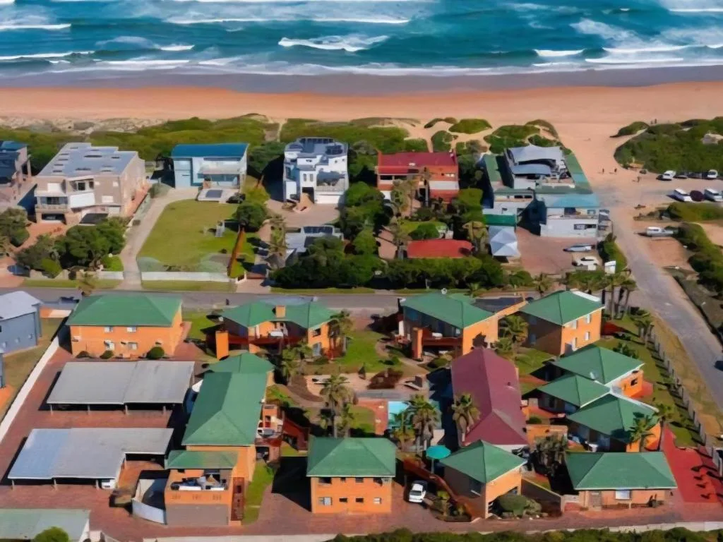 Aerial view of beachfront properties with ocean, sand, and coastal vegetation