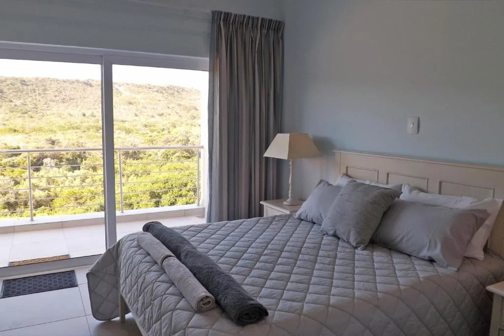Spacious bedroom with queen bed, mountain views through sliding glass doors