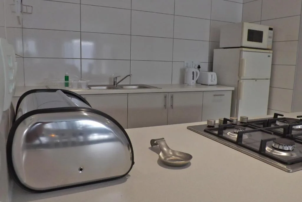 Modern kitchen with gas stove, refrigerator, and white cabinetry