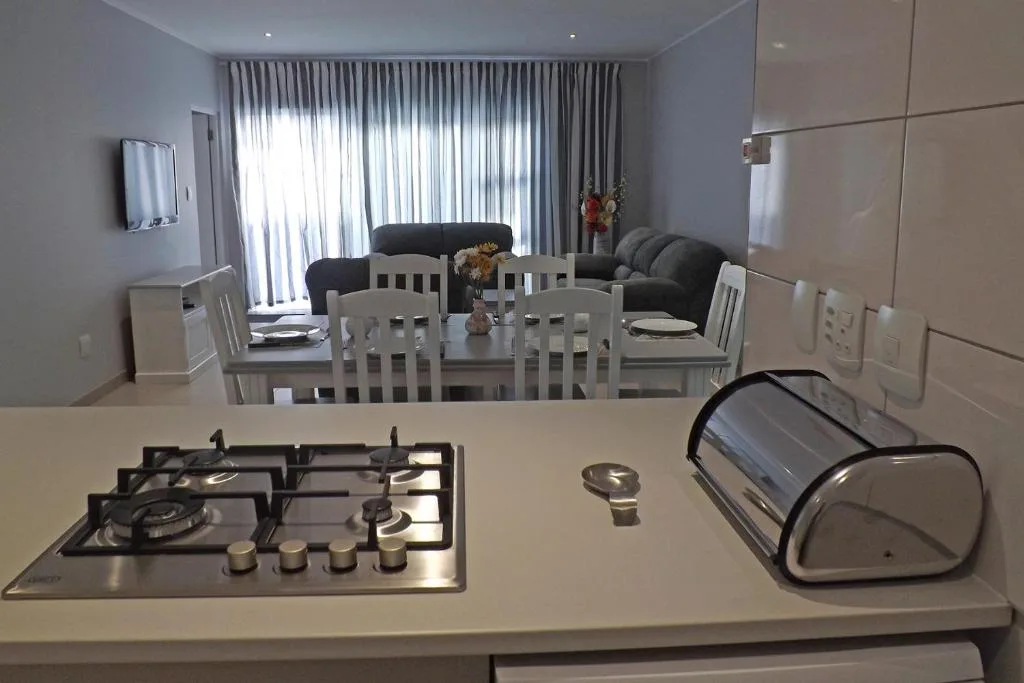 Modern kitchen with gas cooktop and bread bin overlooking open-plan lounge