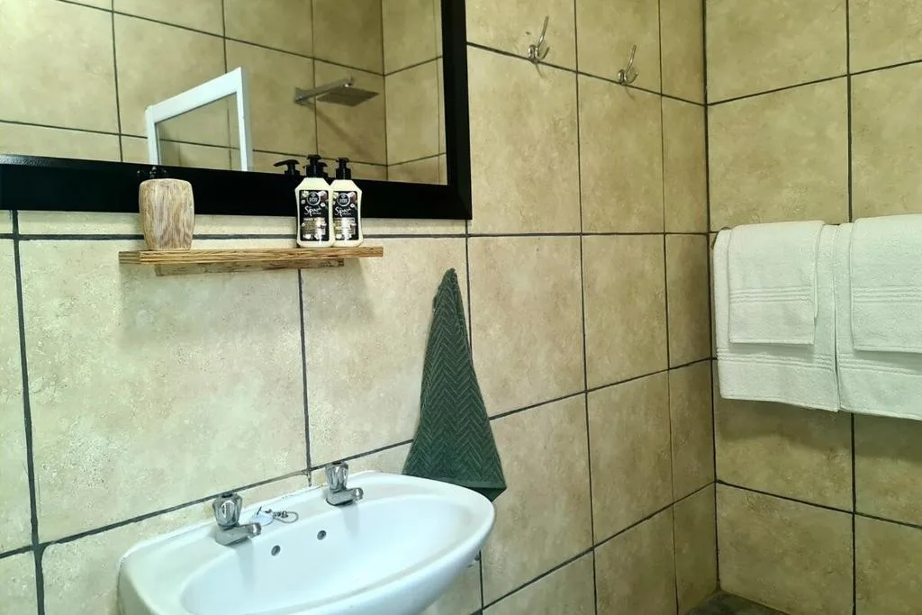 Modern bathroom with vanity sink, large mirror, and tiled walls