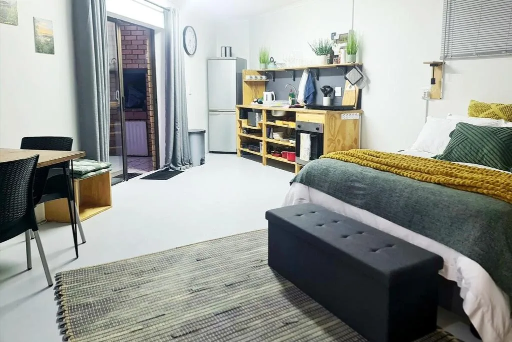 Studio bedroom with bed, kitchenette, desk area, and modern furnishings