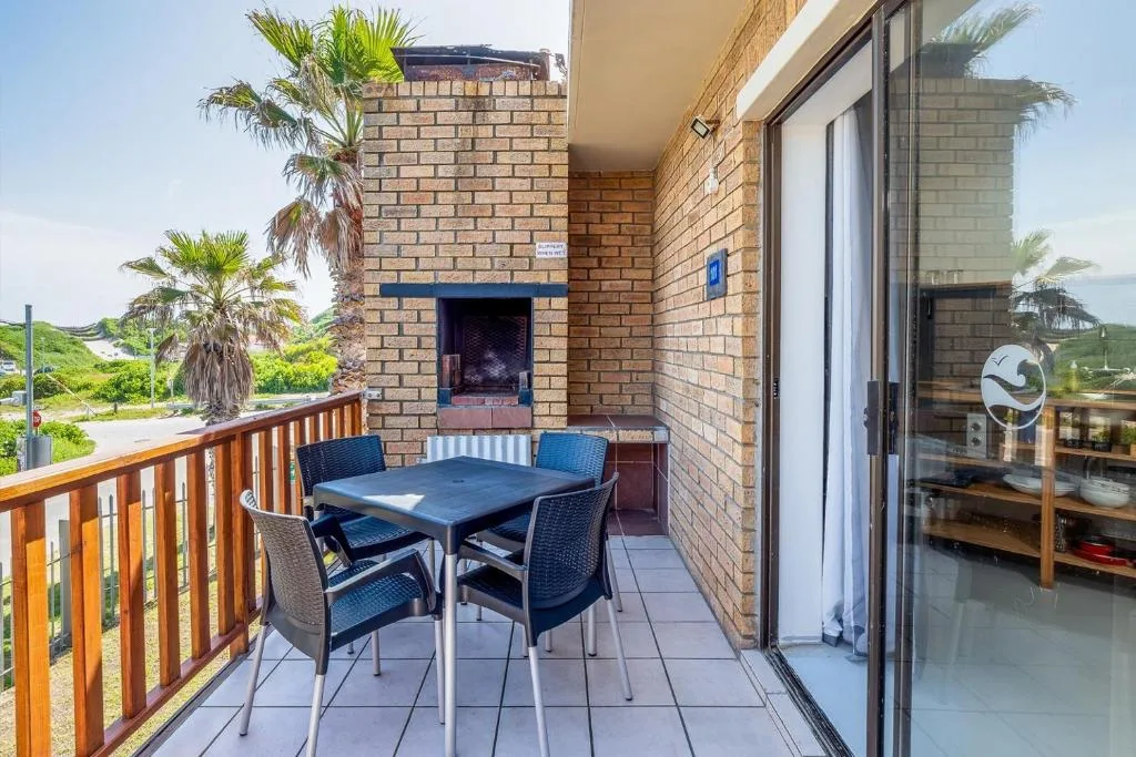 Outdoor deck with dining table, chairs, and brick fireplace