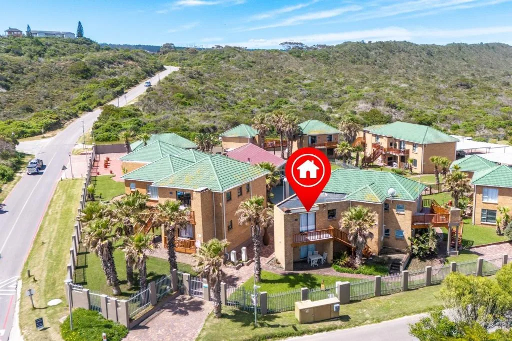 Aerial view of brick cottage with green roof and garden gates