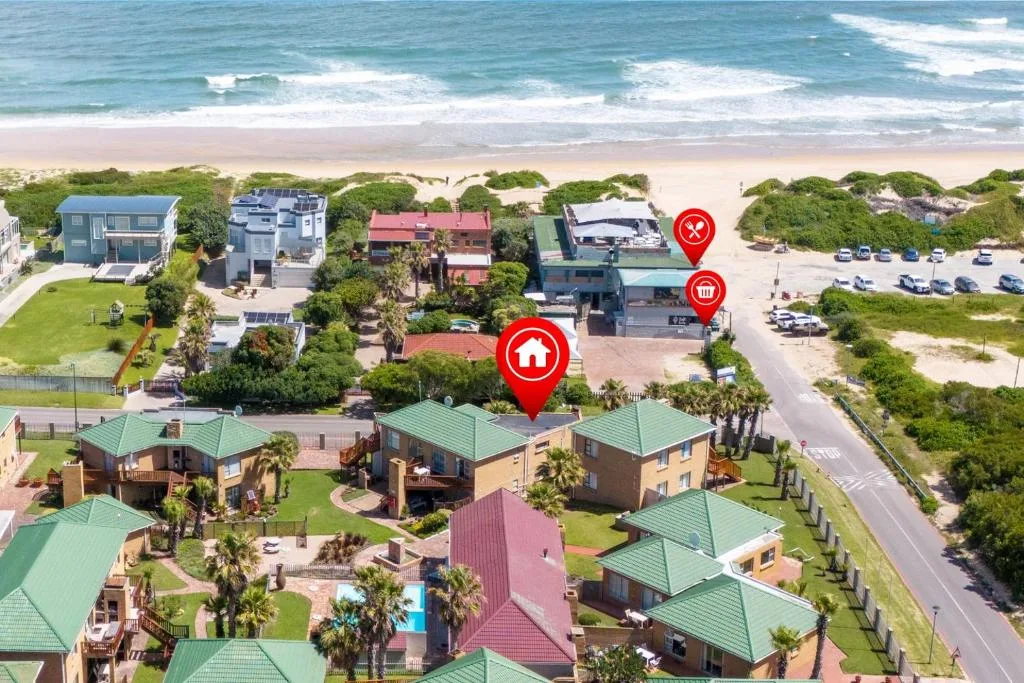 Aerial view of beachfront accommodation complex with ocean and sandy beach beyond