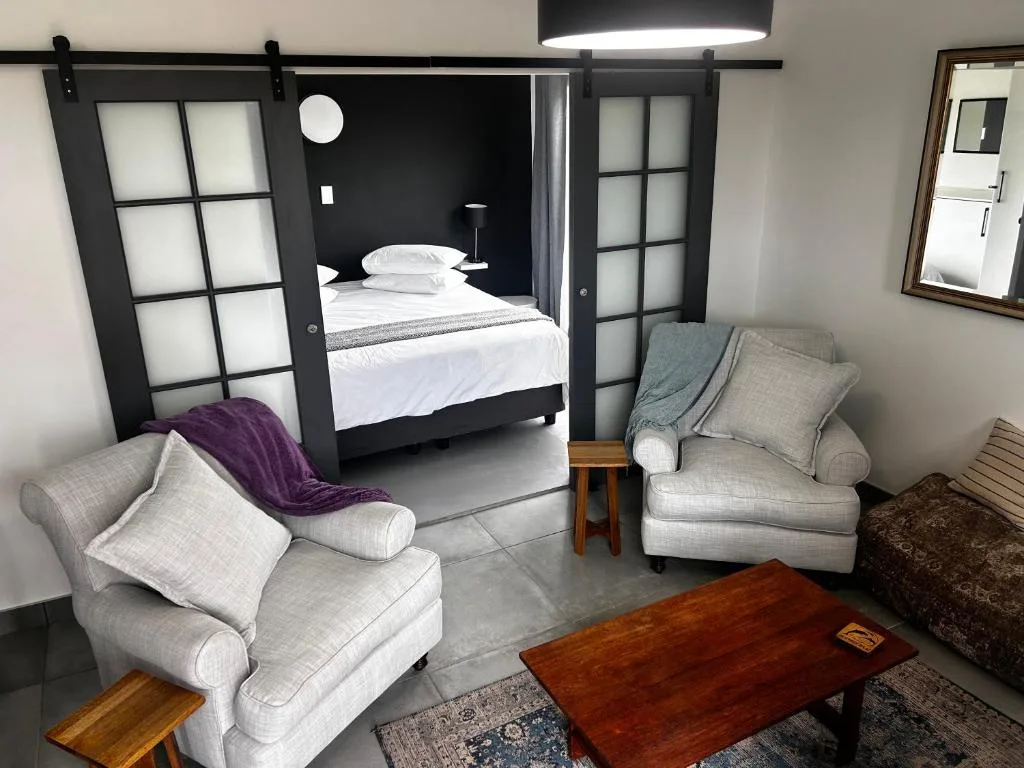 Modern bedroom with four-poster bed and comfortable seating area