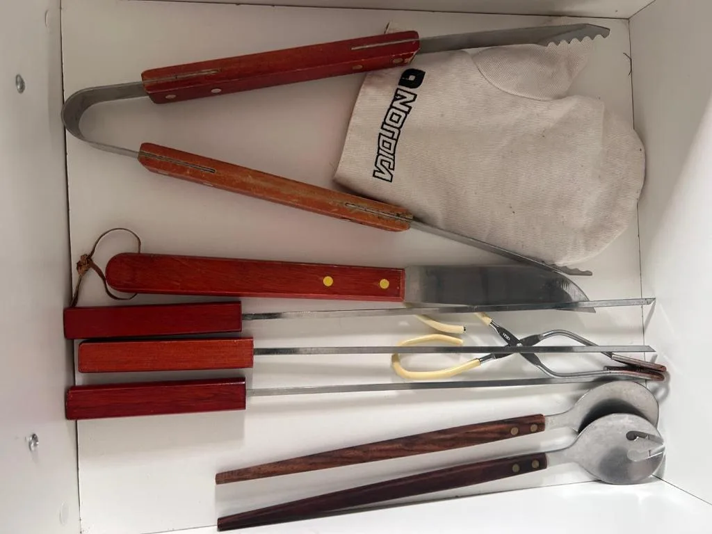 Braai utensils and tools neatly organized in a storage box