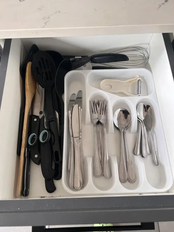 Kitchen drawer with organized utensils, cutlery, and cooking tools neatly arranged