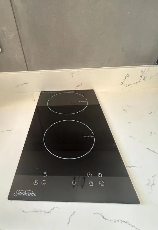 Sunbeam induction cooktop with two burners on marble countertop