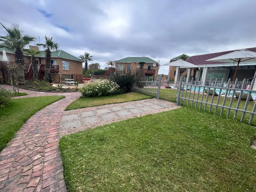Garden Route property with manicured lawns, brick pathways, and palm trees