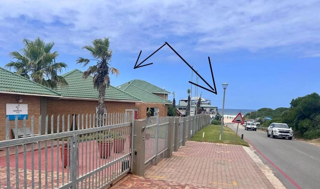 Brick apartment building with green roof and white picket fence entrance
