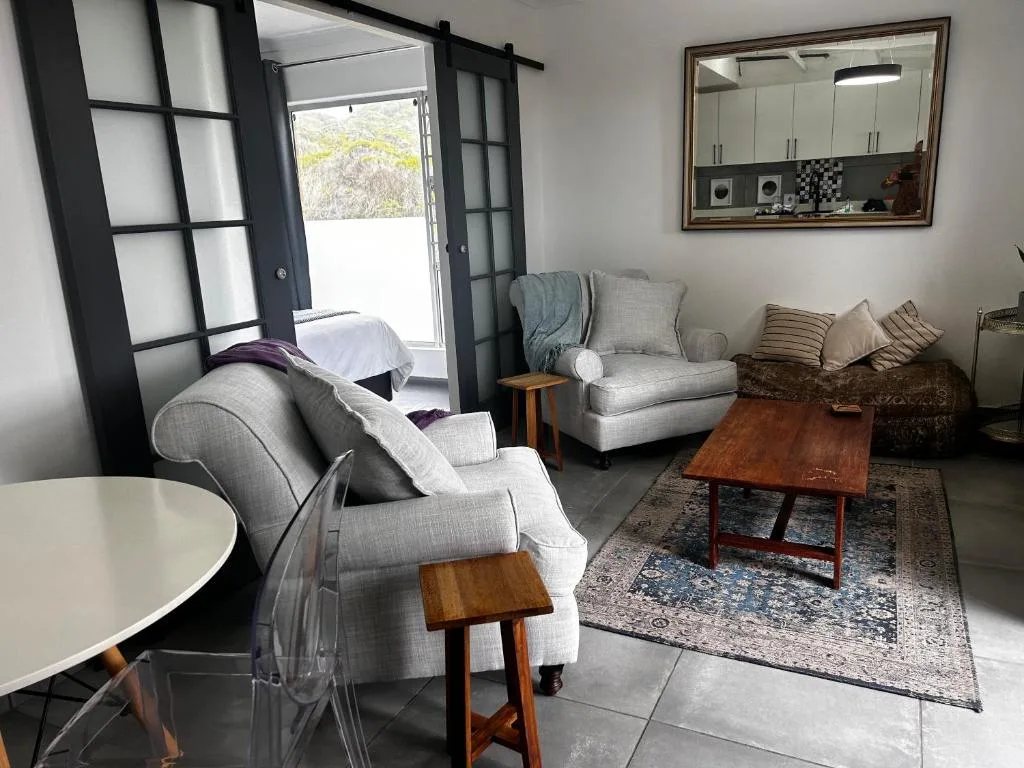 Spacious lounge with grey upholstered chairs and wooden coffee table