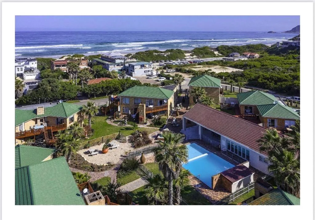 Aerial view of beachfront property with pool overlooking Indian Ocean waves