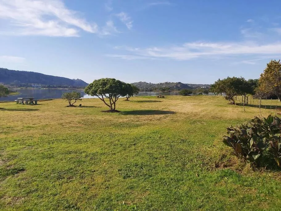 Scenic lagoon view with lush green grounds and distant mountains