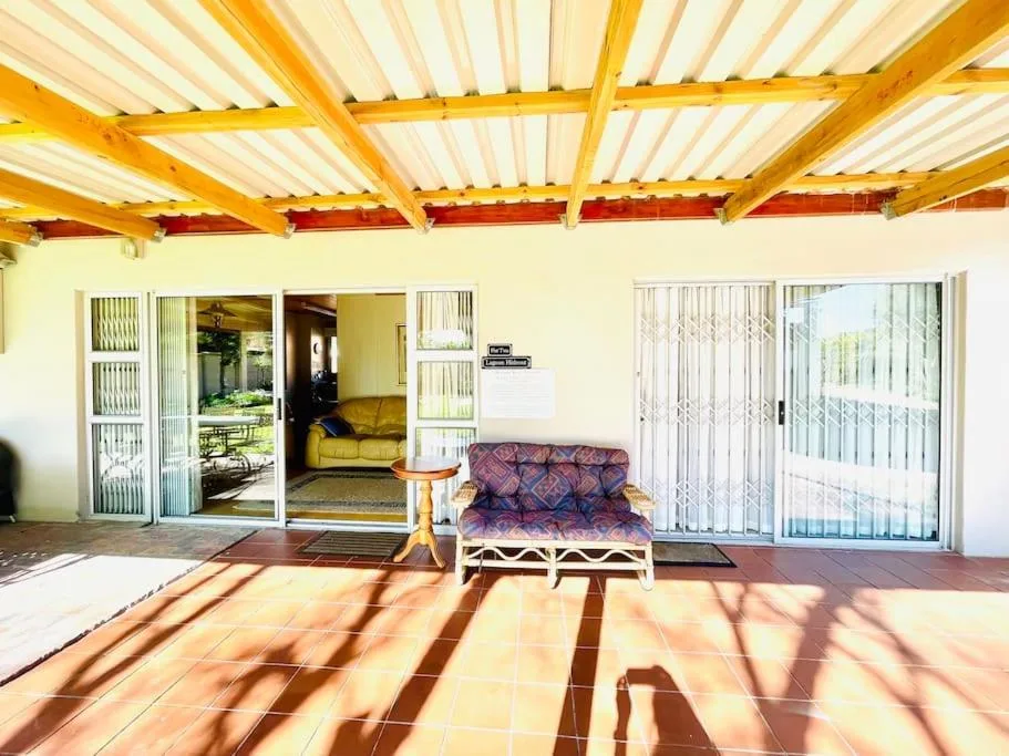 Covered patio with futon, terracotta tiles, and garden views