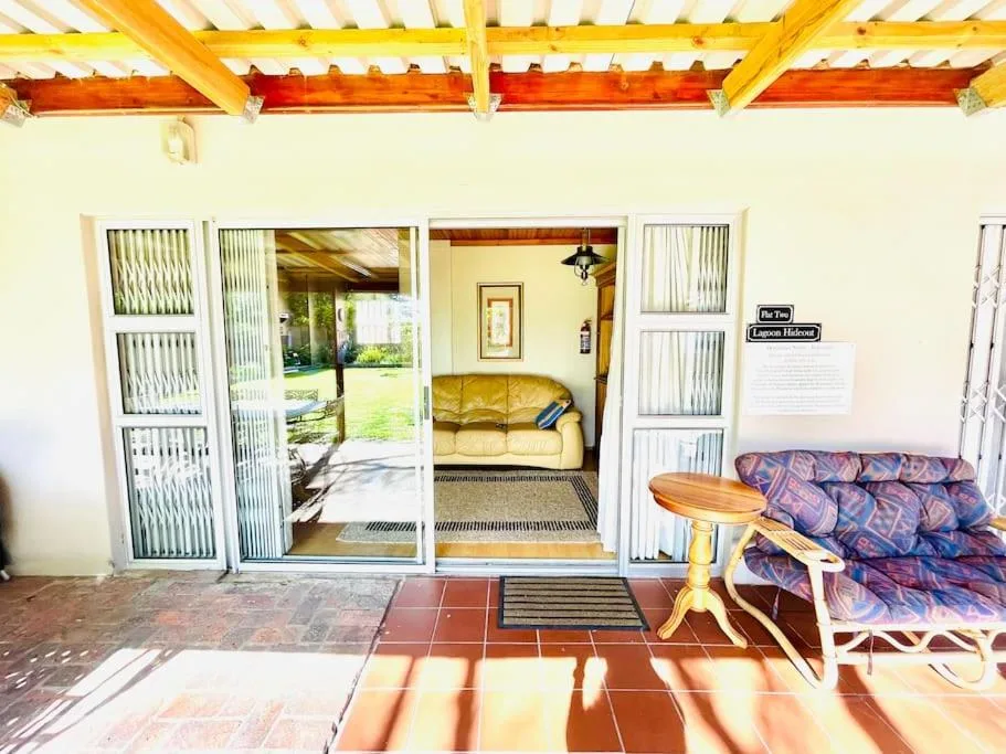 Covered patio with terracotta tiles, striped awning, and garden views