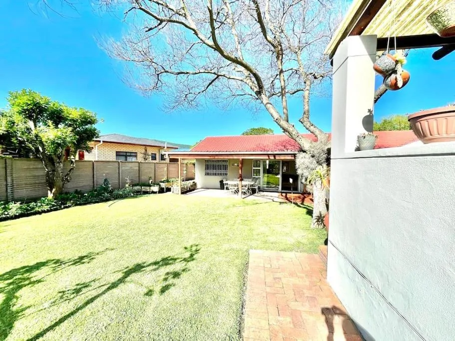 Spacious sunny garden with manicured lawn and charming cottage buildings