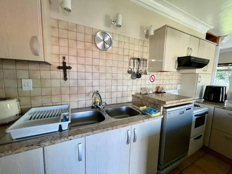 Kitchen with dual sink, stove, and granite countertop with storage