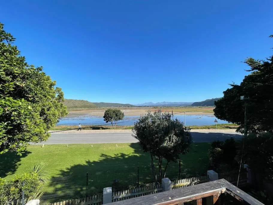 Scenic lagoon and mountain vista from property, lush gardens framing water landscape