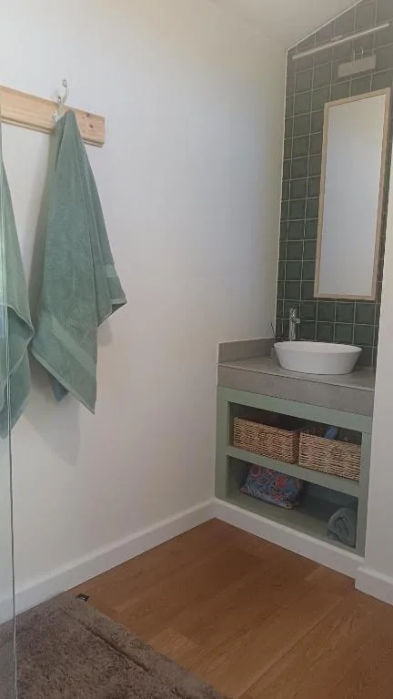 Modern bathroom with white vessel sink and dark tile surround