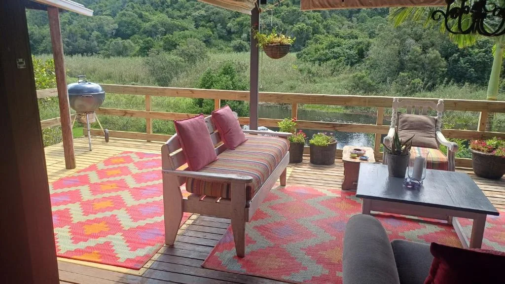 Wooden deck with seating, braai grill, and forest view