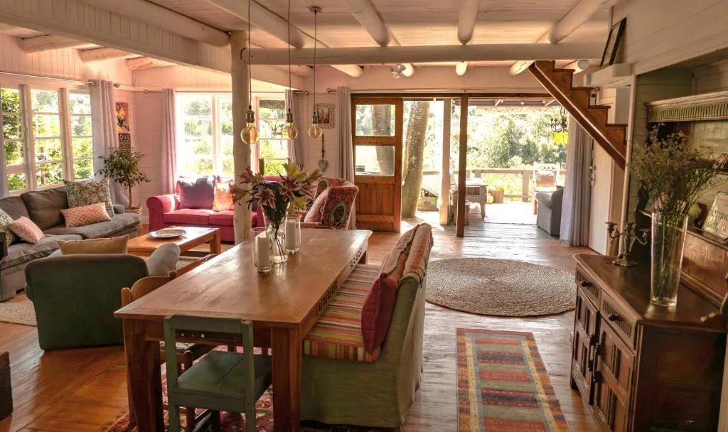 Spacious dining area with wooden table and green upholstered chairs