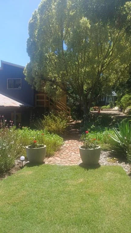 Garden pathway with potted flowers leading to contemporary accommodation building