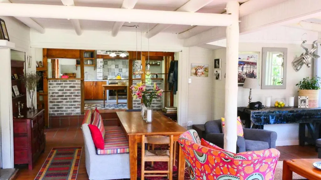 Open-plan lounge with colorful upholstered chairs and wooden dining table