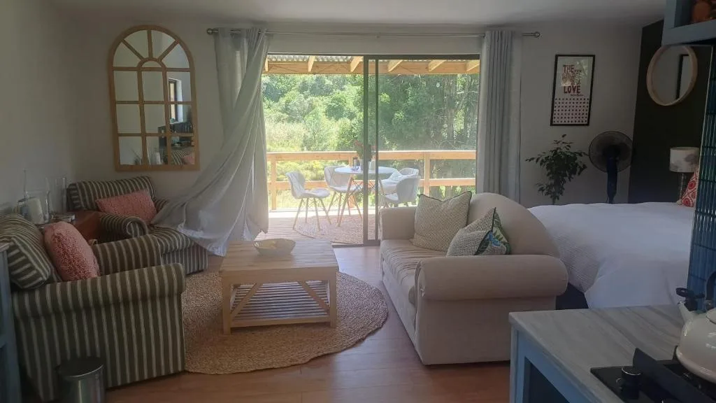 Bright lounge with striped armchairs, white sofa, and deck view