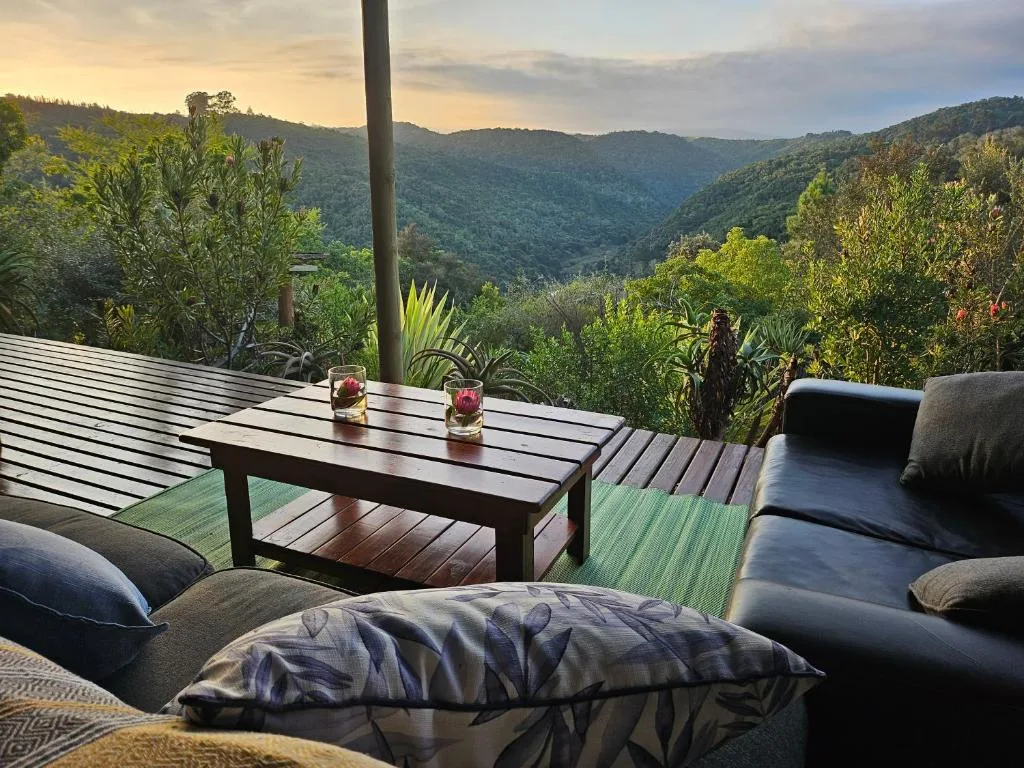 Wooden deck with outdoor seating overlooking forested mountains and valley