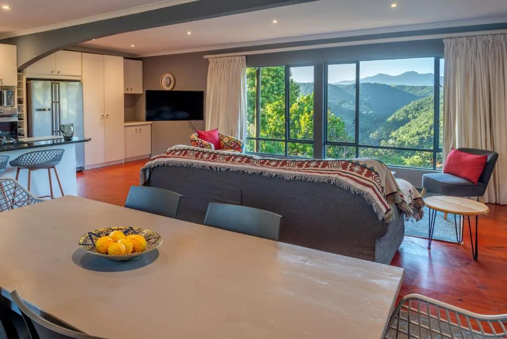 Open-plan lounge with sofa, mountain views through large windows