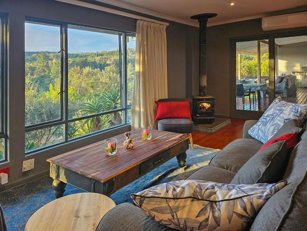 Spacious lounge with comfortable seating, wood stove, and panoramic views
