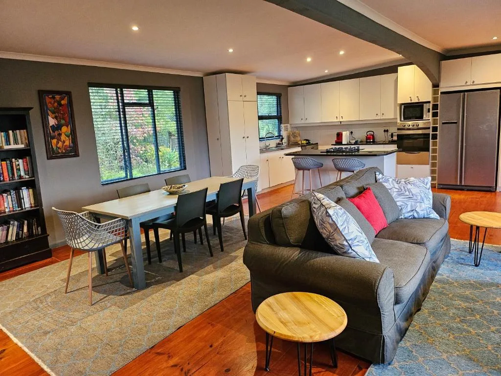 Open-plan lounge with gray sofa, dining area, and kitchen visible beyond