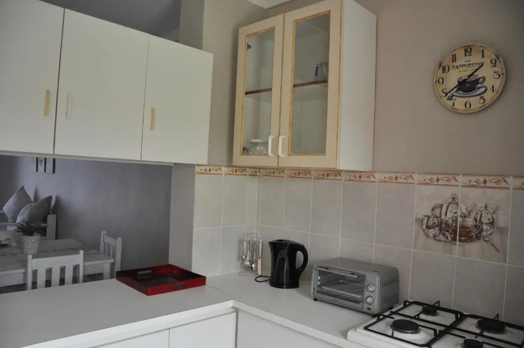 Compact kitchen with white cabinetry, gas cooktop, and modern appliances