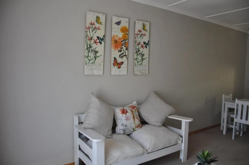 Bright living area with white daybed, floral artwork, and garden-themed decor