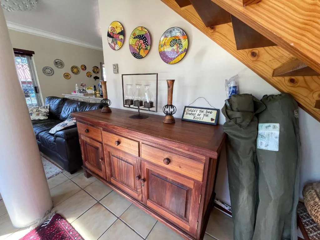 Wooden dresser with decorative plates and home accessories in open plan lounge