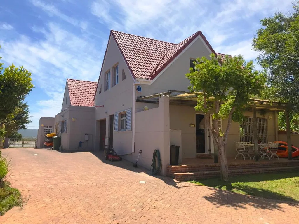 Pink-walled cottage with terracotta roof and brick driveway, Garden Route property