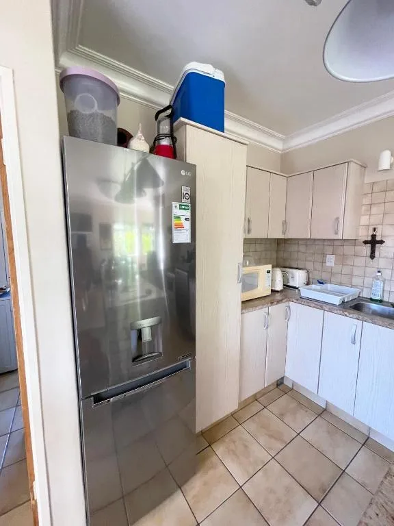 Modern kitchen with stainless steel refrigerator and cream cabinetry
