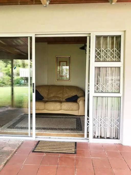 Tan sofa visible through open glass doors from patio area