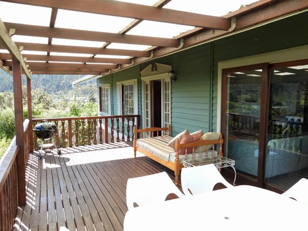 Covered wooden deck with lounge chairs and mountain views