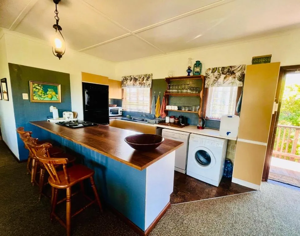 Open-plan kitchen with wooden island, bar seating, and modern appliances