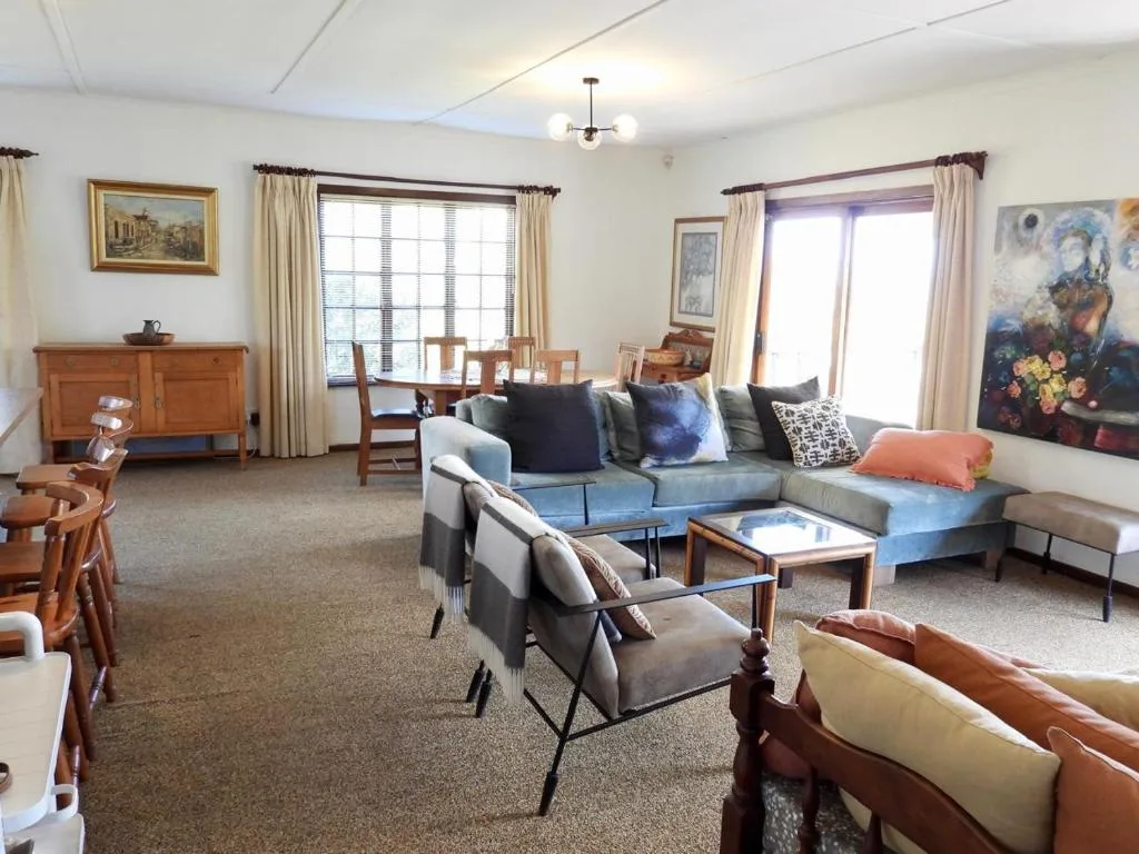 Spacious living room with comfortable seating, large windows, and natural light