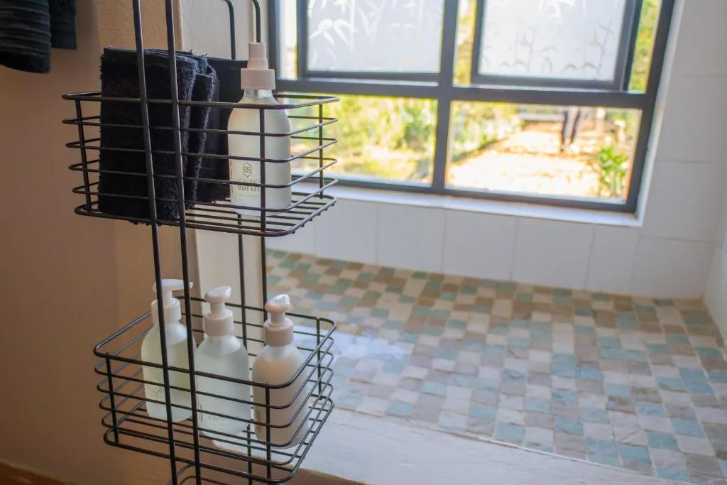 Modern bathroom with wire storage organizer holding toiletries and towels