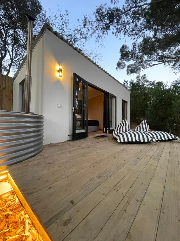 Modern wooden deck with striped loungers and contemporary white cottage