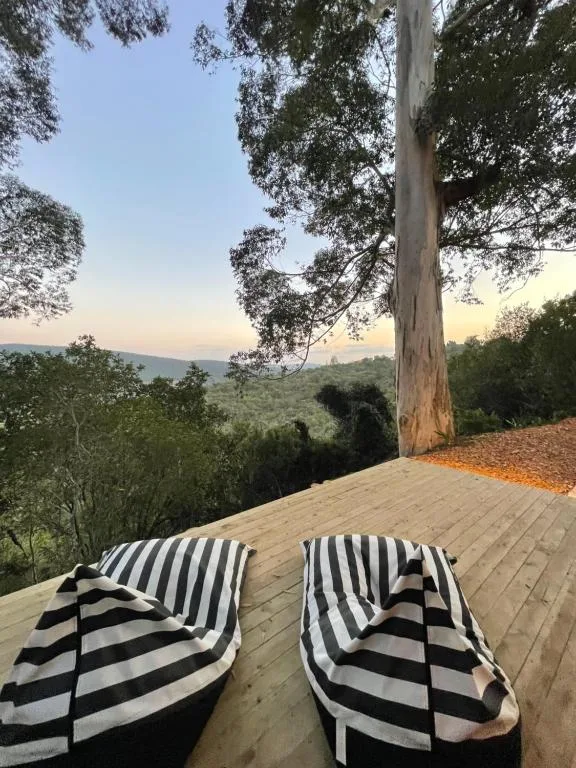Wooden deck with striped loungers overlooking green mountain landscape